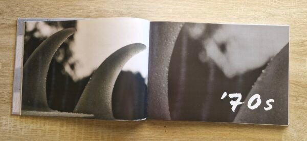 Open pages of Mandurah Surf The Characters and The Coast by Bruce Ellis showing historic surf photography and written stories