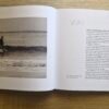 Open pages of Mandurah Surf The Characters and The Coast by Bruce Ellis showing historic surf photography and written stories